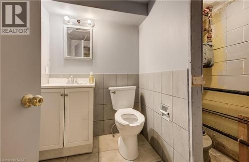 Vanity with white cabinetry, square sink, and wall-mounted light fixture - 1118 King Street E, Cambridge, ON 