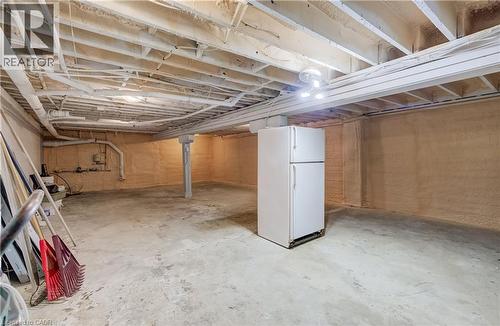 Unfinished basement with concrete flooring, exposed ceiling joists, and a structural support column - 1118 King Street E, Cambridge, ON 
