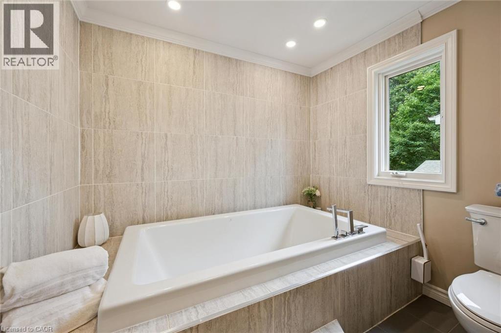Recessed lighting illuminates the tiled bath surround and walls - 334 Coleridge Drive, Waterloo, ON