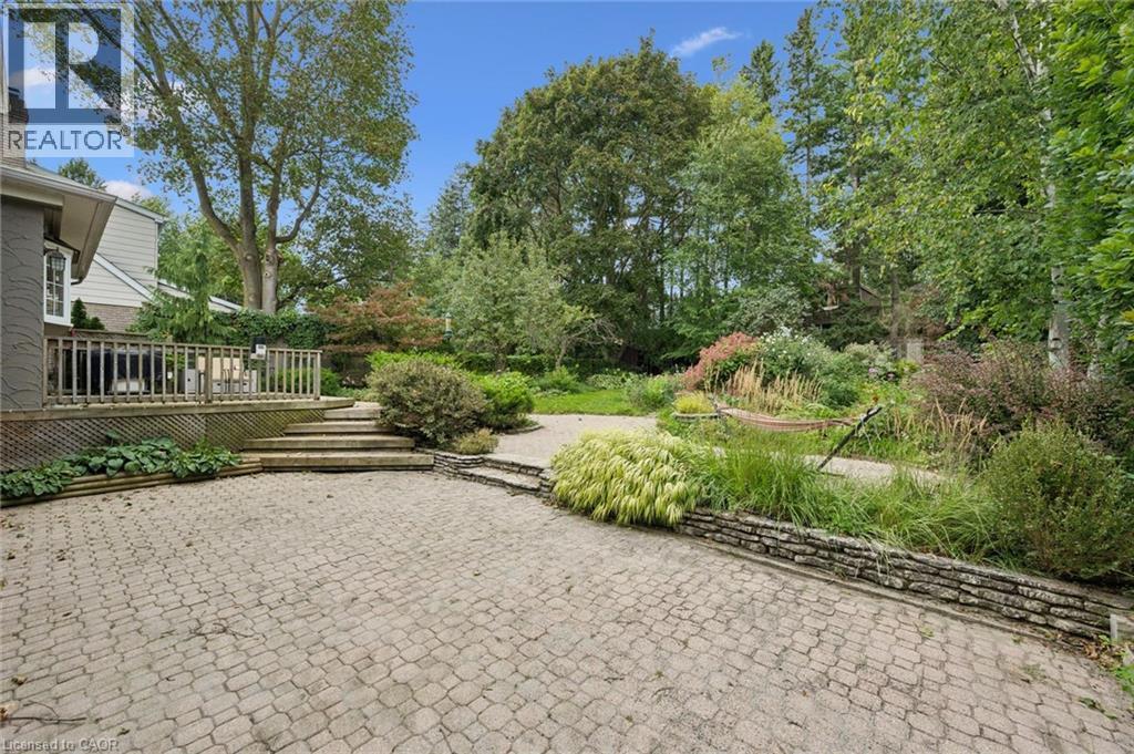 Expansive paver patio with a raised wooden deck and steps - 334 Coleridge Drive, Waterloo, ON