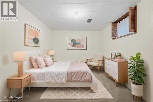 Recessed window with wood shutters, neutral wall paneling, and ceiling tiles - 137 Picton Street E, Hamilton, ON 