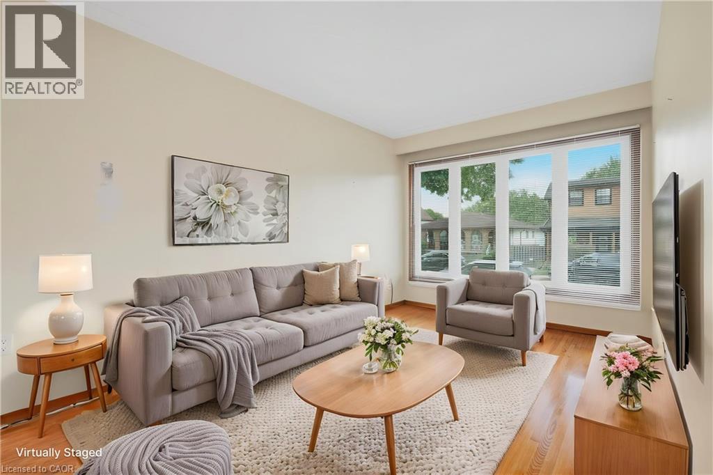 Hardwood flooring, expansive multi-panel window, light-toned wall finishes, recessed lighting, and wall-mounted television - 137 Picton Street E, Hamilton, ON