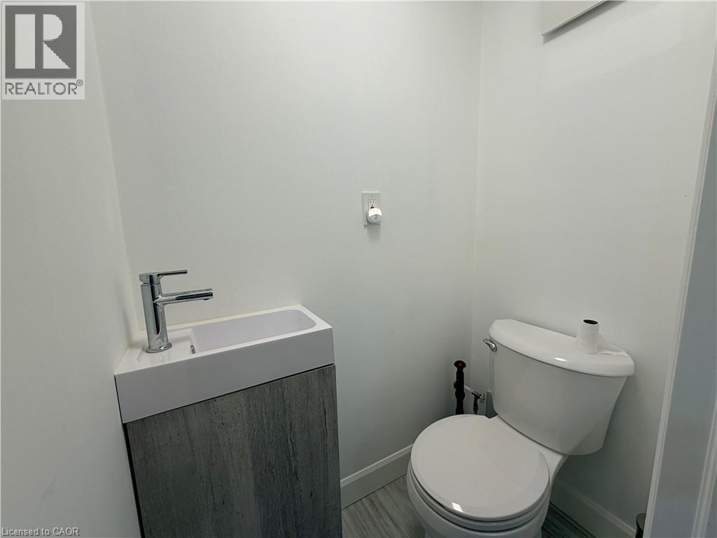 Modern vanity with an integrated basin, chrome faucet, and wood-finish cabinetry - 450 Bridge Street W, Waterloo, ON