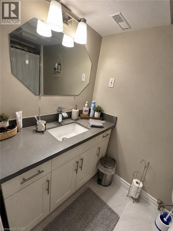 Vanity featuring a mounted sink, gray countertop, and white cabinetry with brushed nickel hardware - 125 Fairgreen Close, Cambridge, ON