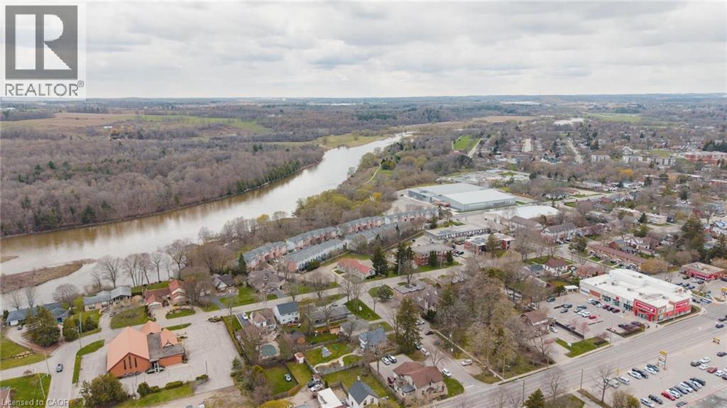 Aerial perspective showcasing a river, extensive tree coverage, and a cluster of townhomes - 245 Bishop Street S Unit# 31, Cambridge, ON