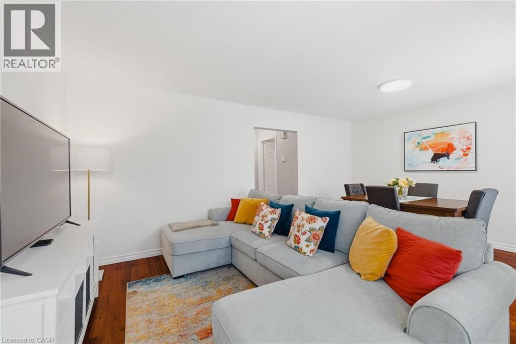 Open-concept living area featuring wood-finish flooring and white baseboards - 245 Bishop Street S Unit# 31, Cambridge, ON