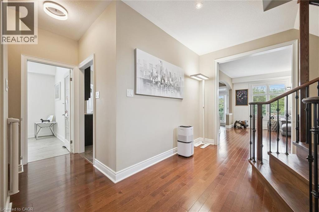 Wood-finish flooring, staircase with wrought iron balusters, recessed lighting, and crown molding - 517 Topper Woods Crescent, Kitchener, ON