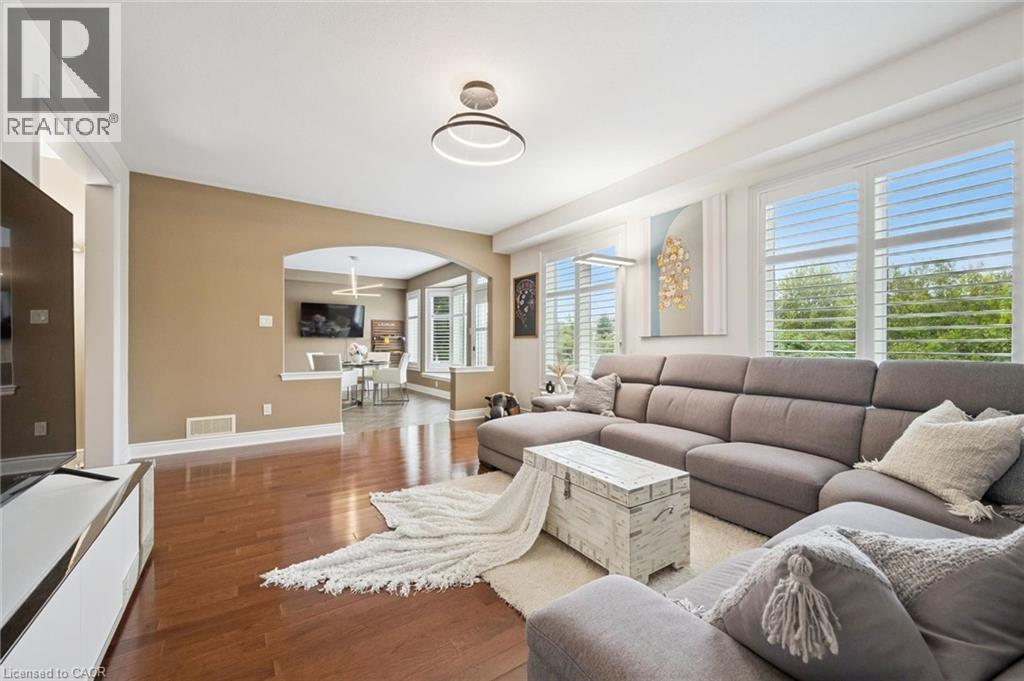 Hardwood flooring, recessed lighting, arched doorway, window shutters, and a modern ceiling light fixture - 517 Topper Woods Crescent, Kitchener, ON