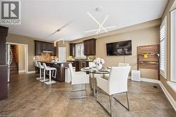 Dark wood cabinetry, stainless steel appliances, tile flooring, modern light fixtures, and window shutters -