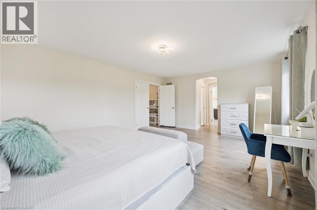 Wood-finish flooring throughout, light neutral wall tones, recessed lighting, and a walk-in closet with built-in shelving - 517 Topper Woods Crescent, Kitchener, ON