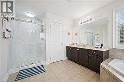 Walk-in shower with clear glass enclosure and tile surround -