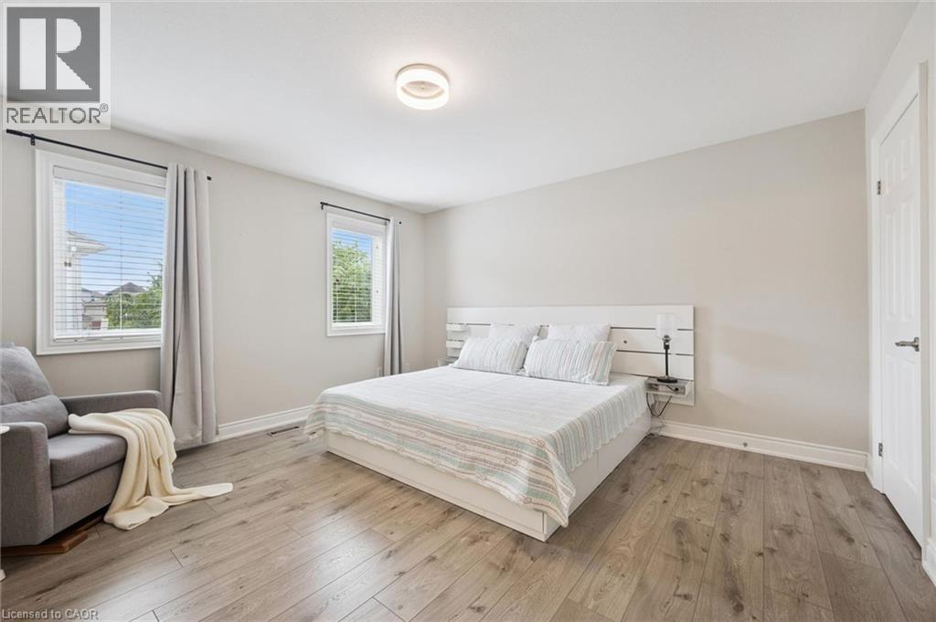 Wood-finish flooring, white trim, recessed lighting, and dual windows with blinds - 517 Topper Woods Crescent, Kitchener, ON