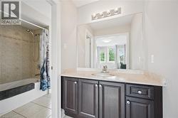Vanity with a light-toned countertop, undermount sink, and dark wood-finish cabinetry -
