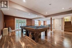 Wood-finish flooring throughout, recessed lighting, and a white paneled door -