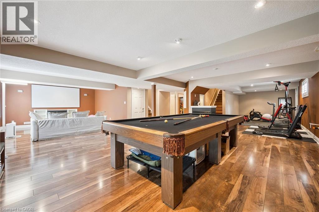 Expansive lower level featuring wood-finish flooring, recessed lighting, and a built-in projection screen - 517 Topper Woods Crescent, Kitchener, ON