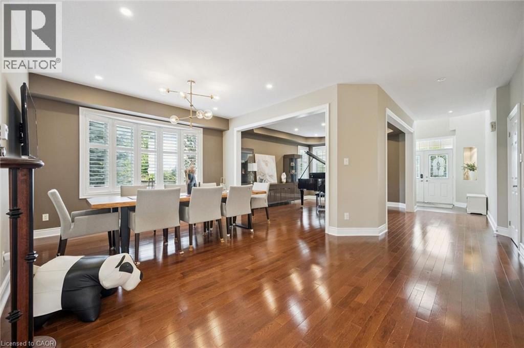 Hardwood flooring, recessed lighting, decorative chandelier, window shutters, and a transom window above the entry door - 517 Topper Woods Crescent, Kitchener, ON