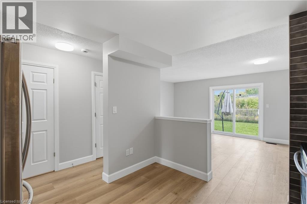 Wood-finish flooring throughout, with white trim and interior doors - 30 S Imperial Road Unit# 3, Guelph, ON