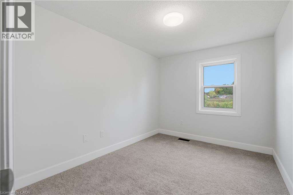 Neutral-toned carpeting, white walls, and a window with white trim - 30 S Imperial Road Unit# 3, Guelph, ON