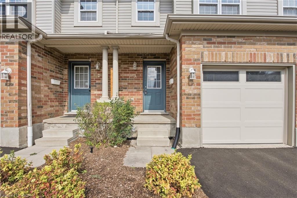Brick and siding exterior with concrete steps, covered entry, and integrated garage featuring transom windows - 30 S Imperial Road Unit# 3, Guelph, ON