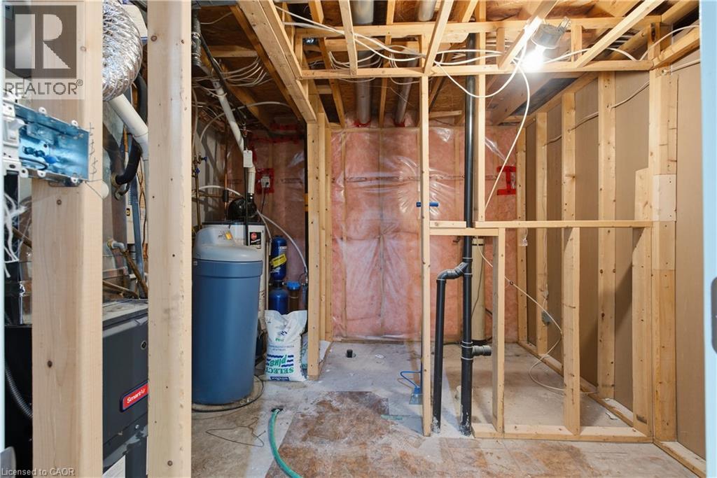 Unfinished basement with exposed wood framing, visible plumbing, and a water softener system - 30 S Imperial Road Unit# 3, Guelph, ON