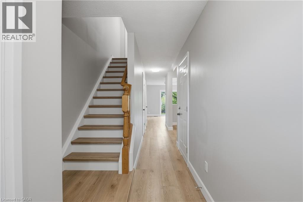 Hallway featuring wood-finish flooring and light gray painted walls - 30 S Imperial Road Unit# 3, Guelph, ON