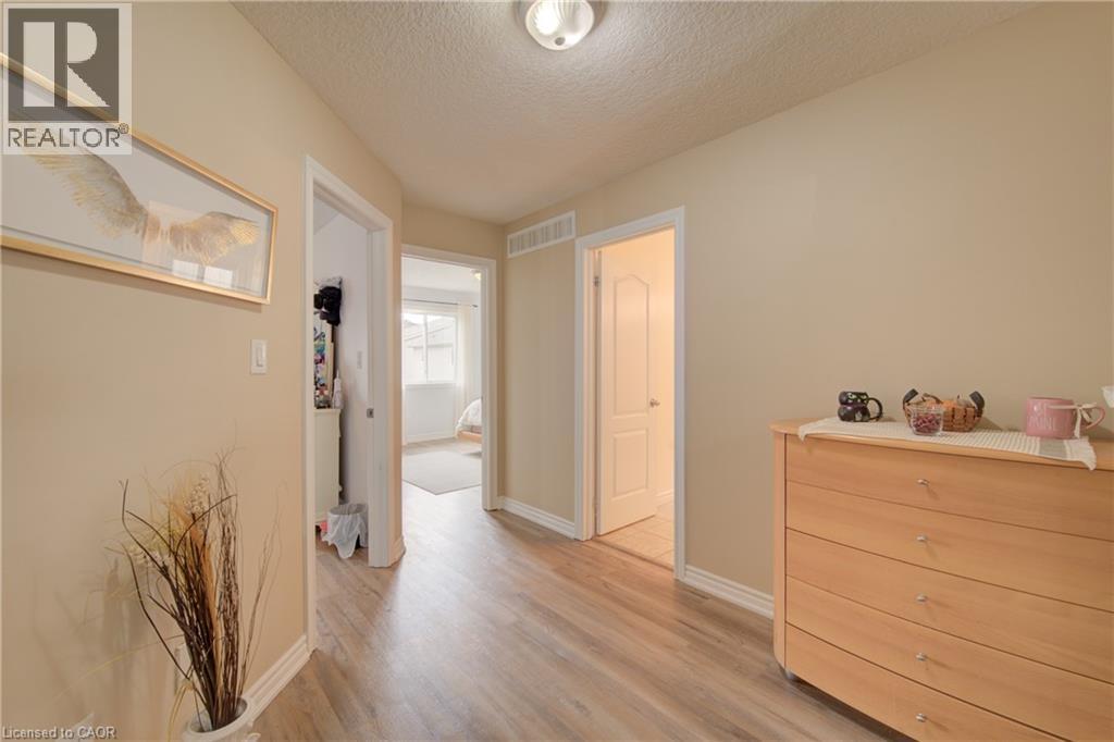 Hallway featuring wood-finish flooring, neutral wall paint, white trim, and recessed lighting - 78 Stuckey Avenue, Baden, ON