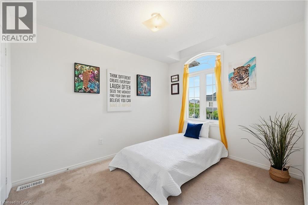 Arched window with gridded panes, white painted walls, and light brown carpeting - 3198 Tim Dobbie Drive, Burlington, ON