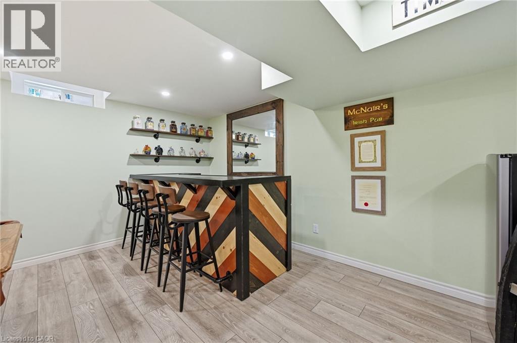 Built-in bar with chevron wood-finish paneling and dark countertop - 3198 Tim Dobbie Drive, Burlington, ON