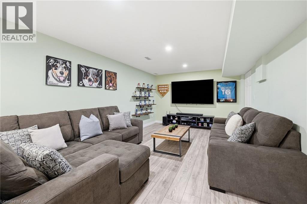 Recessed lighting illuminates the expansive room featuring wood-finish flooring - 3198 Tim Dobbie Drive, Burlington, ON