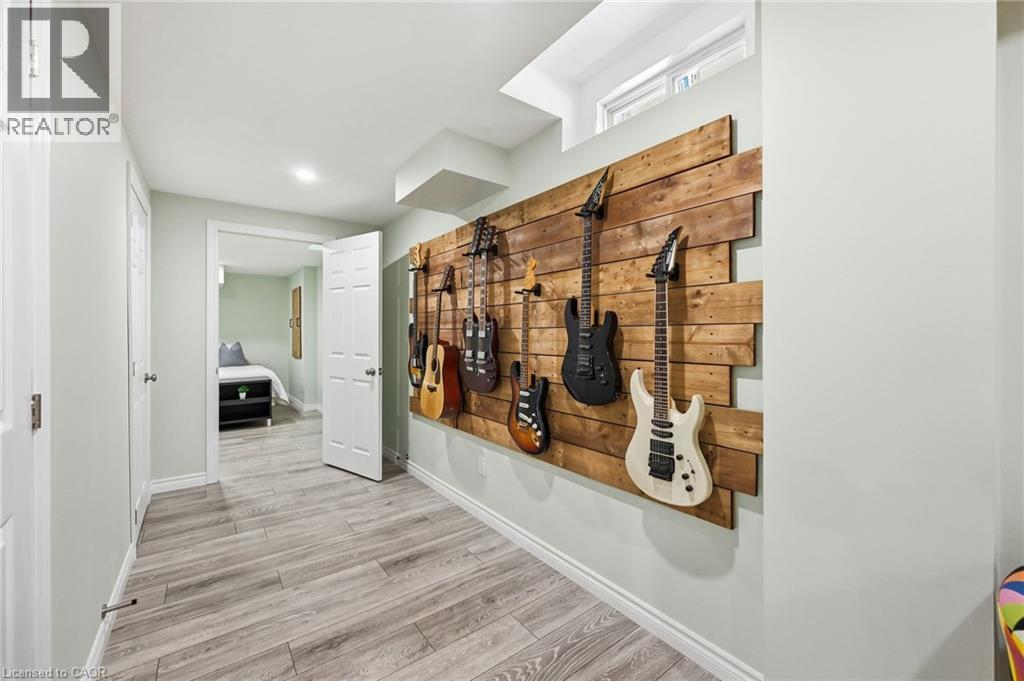 Wood-finish flooring throughout, featuring a recessed light fixture and a wood-paneled accent wall - 3198 Tim Dobbie Drive, Burlington, ON