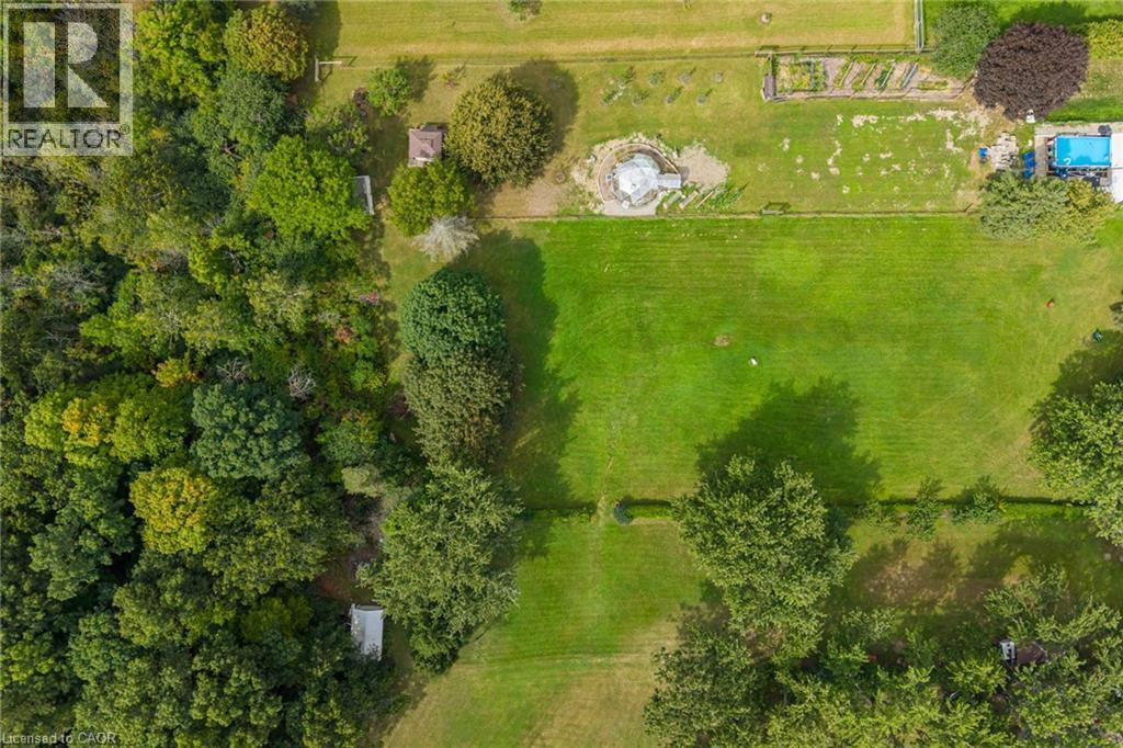 Expansive green lawn areas, mature perimeter trees, established garden beds, and a built-in outdoor pool - 1412 Old York Road, Burlington, ON