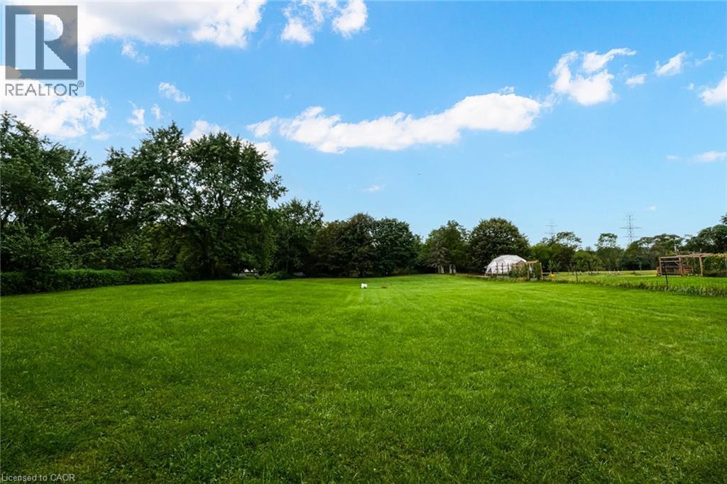 Expansive green lawn with mature perimeter trees and a translucent dome structure - 1412 Old York Road, Burlington, ON