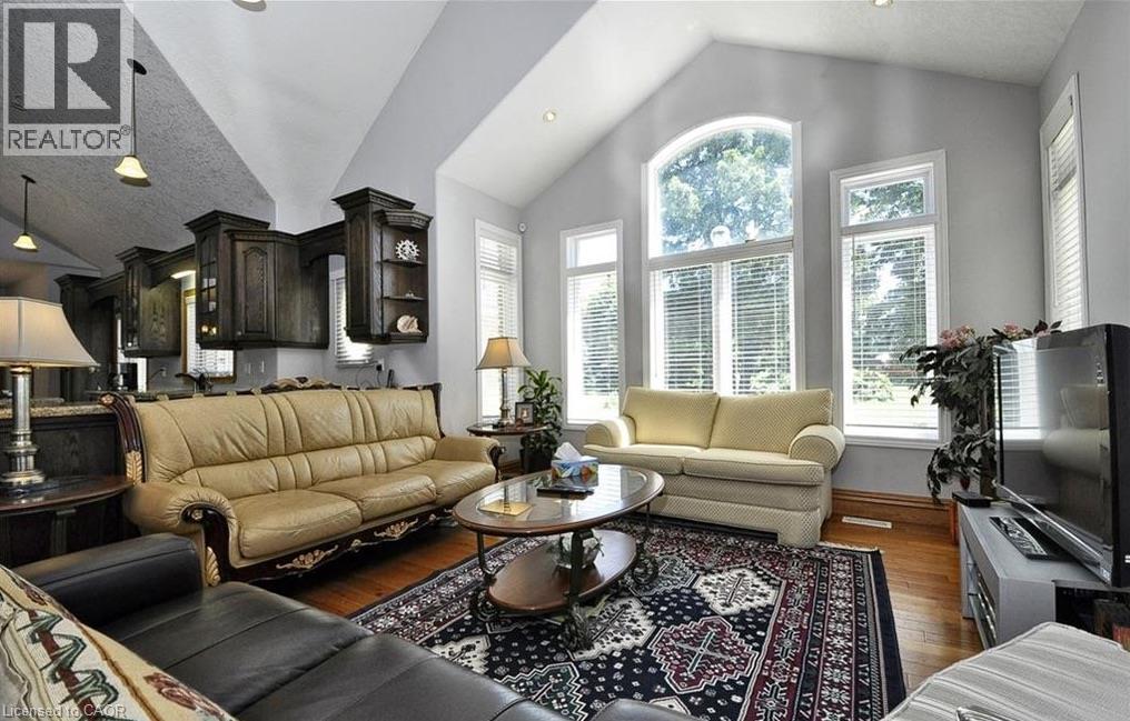 Vaulted ceilings, wood-finish flooring, dark wood cabinetry, and extensive natural light through large windows - 915 Briardean Road, Cambridge, ON