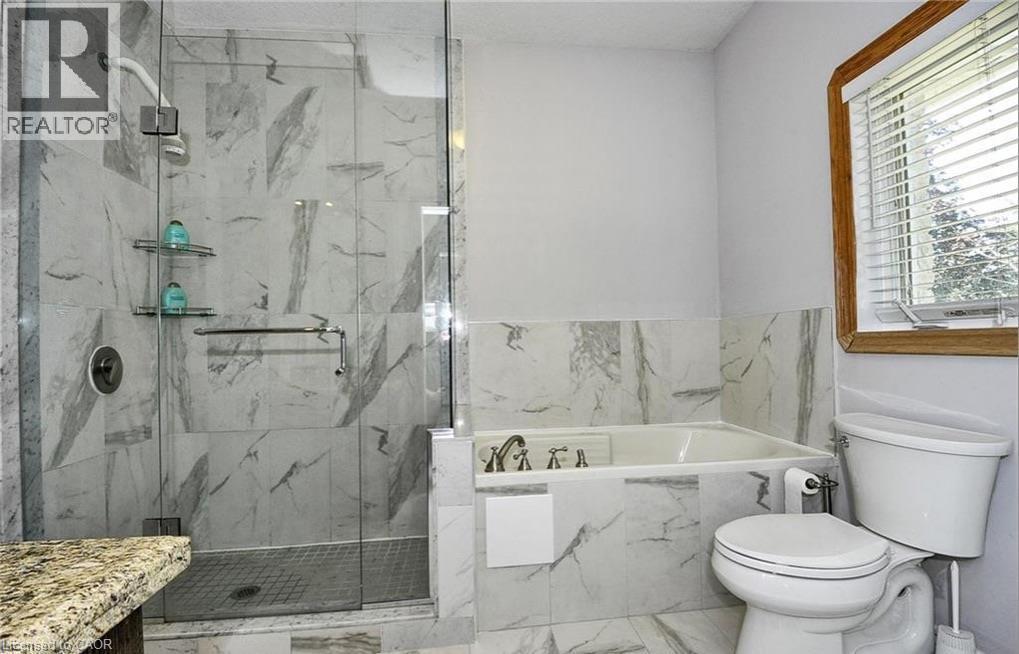 Glass-enclosed shower with tiled walls and a built-in tub - 915 Briardean Road, Cambridge, ON