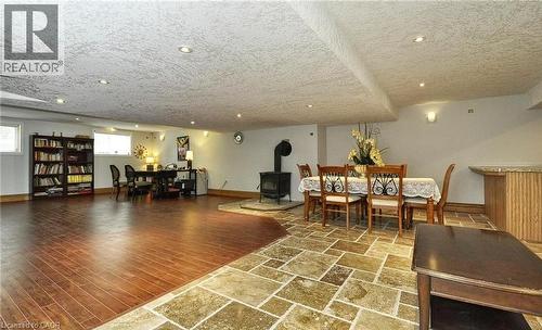 Recessed ceiling lighting, wood-finish flooring, stone tile flooring, built-in shelving, and a wood-burning stove - 915 Briardean Road, Cambridge, ON 