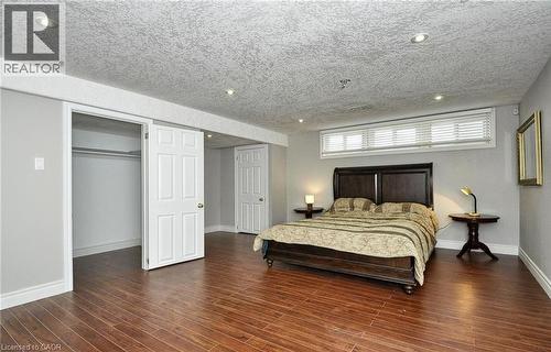 Recessed lighting illuminates the room, featuring wood-finish flooring and light gray walls - 915 Briardean Road, Cambridge, ON 