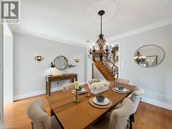 Hardwood flooring, decorative ceiling medallion, ornate chandelier, crown molding, and a built-in staircase -