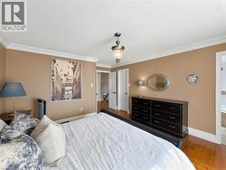 Hardwood flooring, crown molding, double white interior doors, and a ceiling-mounted light fixture -