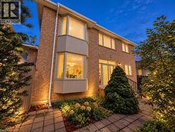 Brick exterior featuring multiple windows, a bay window, and a glass-paneled door -