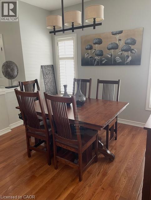 Hardwood flooring, window with plantation shutters, ceiling-mounted linear chandelier - 5383 Haldimand Crescent, Burlington, ON
