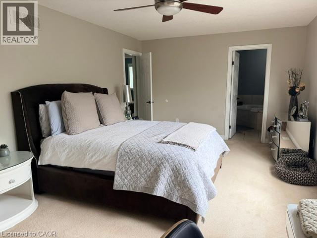 Carpeted room with a ceiling fan, recessed lighting, and access to an ensuite bathroom featuring a tub - 5383 Haldimand Crescent, Burlington, ON