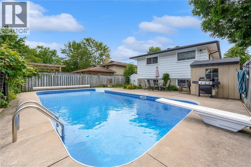 Rectangular inground pool with concrete surround and diving board - 7506 Jubilee Drive, Niagara Falls, ON