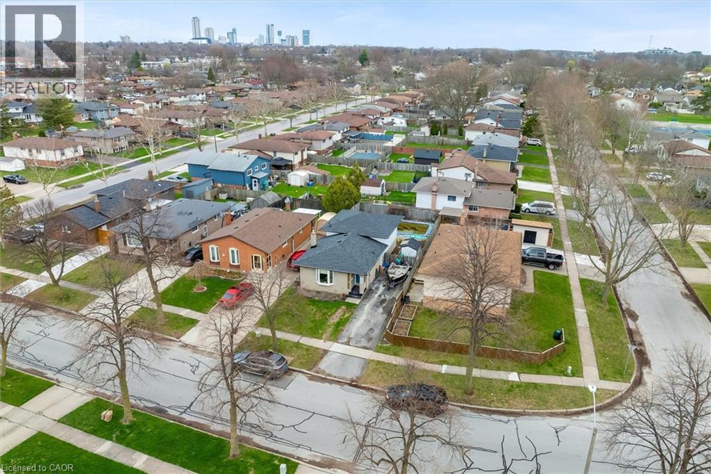 This aerial view showcases a residential street lined with houses and mature trees - 7506 Jubilee Drive, Niagara Falls, ON
