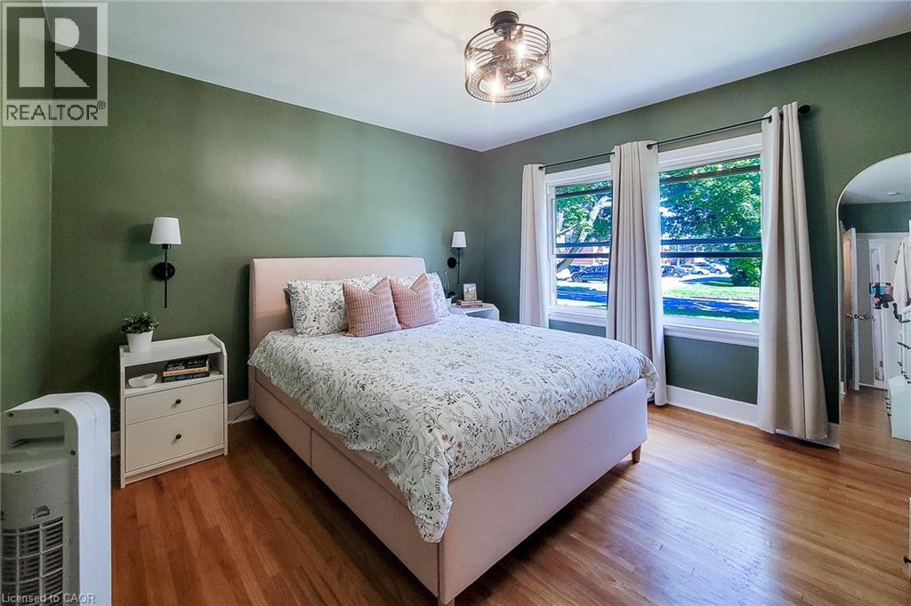 Hardwood flooring, two windows with trim, ceiling fan, and wall-mounted sconces - 19 Thorndale Avenue, St. Catharines, ON