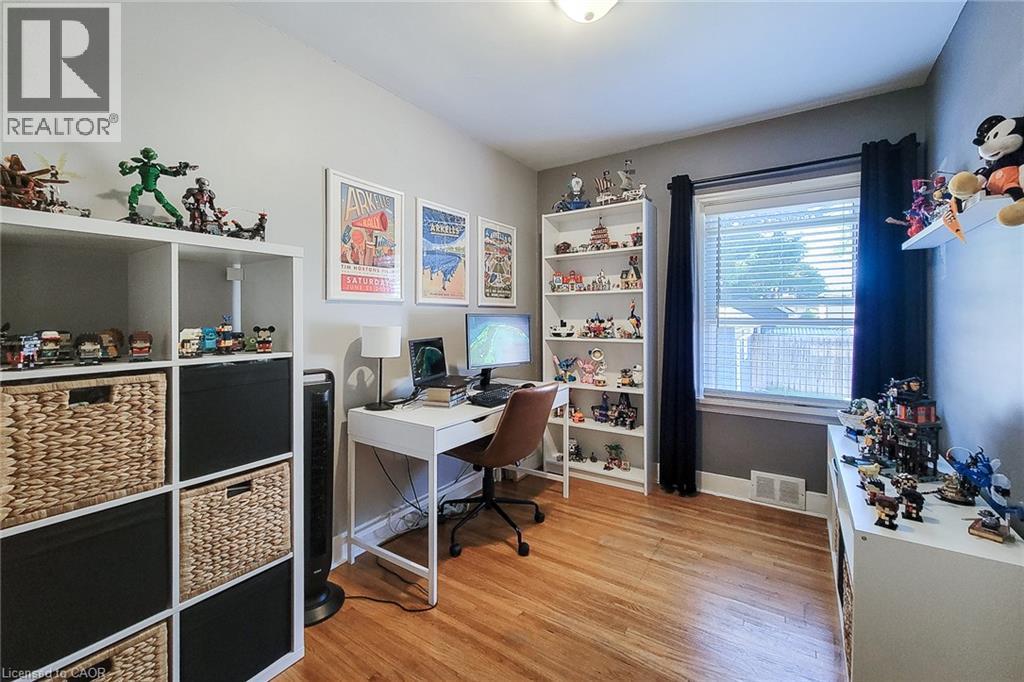 Hardwood flooring, window with blinds, recessed ceiling light, built-in shelving, and a wall-mounted desk - 19 Thorndale Avenue, St. Catharines, ON