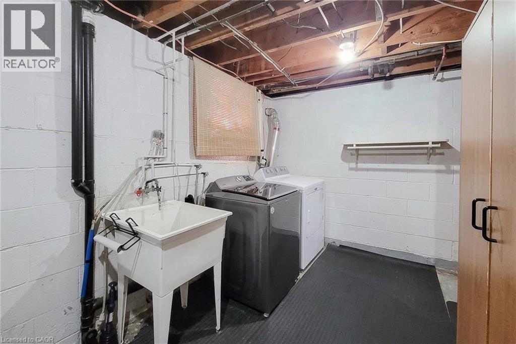 Laundry area featuring a utility sink, exposed ceiling beams, and a built-in storage cabinet - 19 Thorndale Avenue, St. Catharines, ON