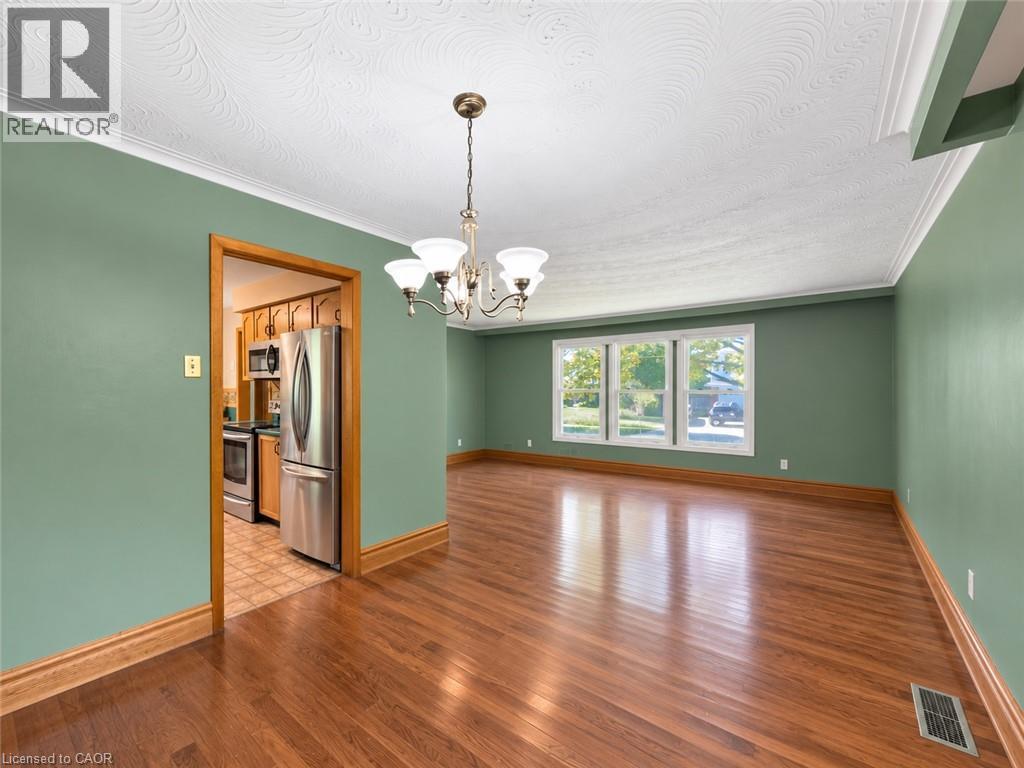 Hardwood flooring, decorative ceiling texture, crown molding, chandelier, and a triple window - 2490 Yarmouth Crescent, Oakville, ON