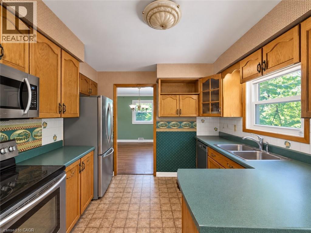 Wood-finish cabinetry, stainless steel appliances, dual basin sink, and ample counter space - 2490 Yarmouth Crescent, Oakville, ON