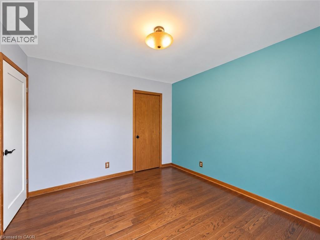 Wood-finish flooring with coordinating wood trim, a ceiling-mounted light fixture, and a solid wood door - 2490 Yarmouth Crescent, Oakville, ON