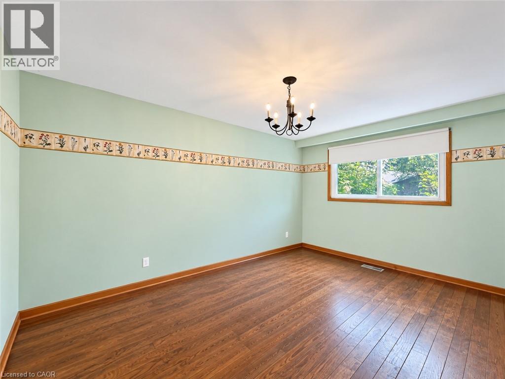 Wood-finish flooring, single window, chandelier light fixture, and decorative wall border - 2490 Yarmouth Crescent, Oakville, ON
